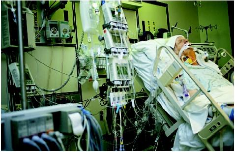This man is recovering from quadruple bypass surgery in an intensive care unit. (Custom Medical Stock Photo. Reproduced by permission.)