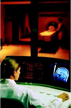 A patient receiving a magnetic resonance imaging (MRI) scan. A technologist monitors the equipment in an adjacent control room. (Will & Deni McIntyre/Photo Researchers, Inc. Reproduced by permission.)